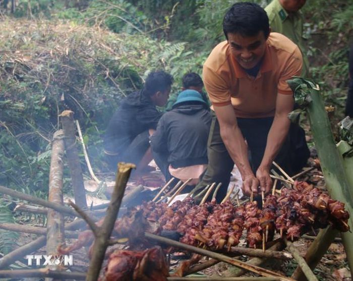 Thanh niên trong làng chuẩn bị những món ăn đặc sản để thiết đãi khách trong Lễ cúng rừng. (Ảnh: Hồng Điệp/TTXVN)