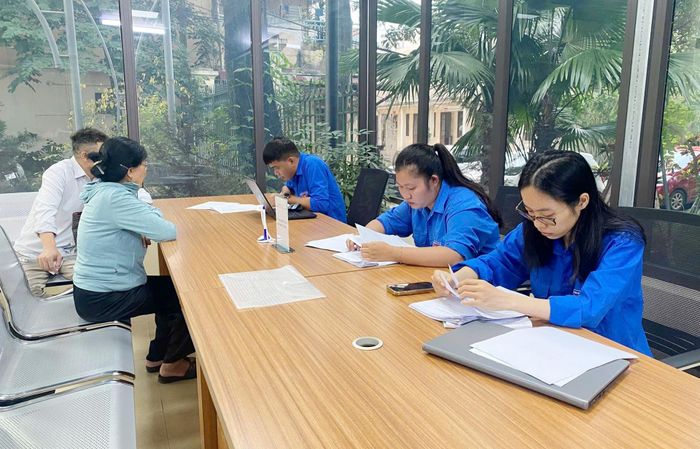 Đoàn viên thanh niên xã Đan Phượng hỗ trợ người dân làm thủ tục hành chính. Ảnh: Quang Biện