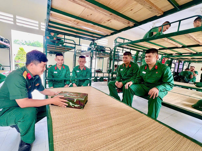 Cán bộ trung đội hướng dẫn hai cặp song sinh sắp xếp nội vụ. 