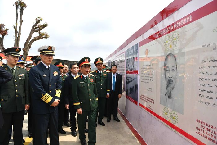 Hai Bộ trưởng tham quan bức tường trưng bày các nội dung liên quan đến "Đường Hồ Chí Minh trên biển". Ảnh: BQP