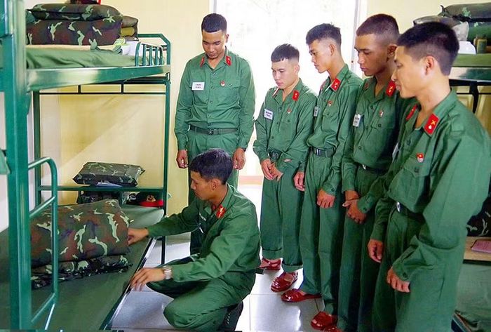  Hướng dẫn chiến sĩ mới gấp chăn màn trong những ngày đầu nhập ngũ ở Trung đoàn Thông tin 29. Ảnh: T.D 