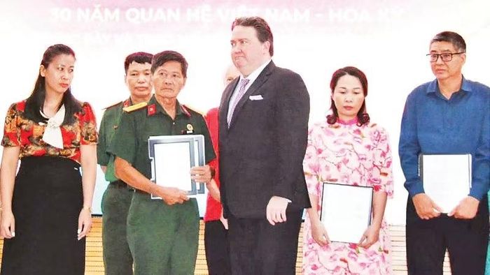 Cựu Đại sứ Hoa Kỳ tại Việt Nam Marc Knapper trao trả hồ sơ thời chiến cho đại diện Ban liên lạc Đoàn công tác chính sách quy tập hài cốt liệt sĩ Sư đoàn 308 và các thân nhân liệt sĩ.