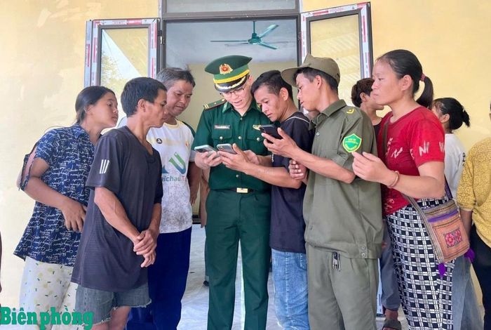 Thiếu tá Bàn Vũ Hậu hướng dẫn người dân thực hiện các tác vụ trên ứng dụng dịch vụ công, tra cứu thông tin về chính sách. Ảnh: Biên Cương