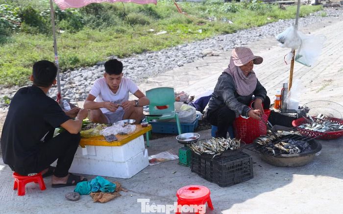  Anh Nguyễn Phúc Hùng (25 tuổi, áo trắng) hiện đang làm việc tại Hà Nội, cho biết, những ngày qua, món cá trích nướng được chia sẻ nhiều trên mạng xã hội nên tranh thủ được nghỉ, anh trở về quê Hải Châu để trực tiếp thưởng thức cùng bạn. “Phải về tận nơi, ngồi bên bếp than hồng, ăn cá vừa nướng xong mới cảm nhận hết được cái ngon, cái ngọt rất riêng của cá trích nơi đây”, anh Hùng chia sẻ. 