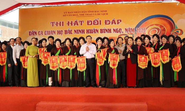 Ban Tổ chức hội thi trao cờ lưu niệm cho các cặp tham gia nội dung thi đối đáp quan họ.