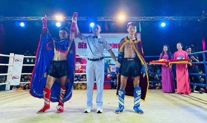 Võ sĩ Bùi Trọng Phi (bên trái, võ đường Kim Minh Công) giành chiến thắng võ sĩ Lê Phúc Hưởng (võ đường Trần Thiên Dũng) ở hạng cân 48 kg. Ảnh: ĐVCC