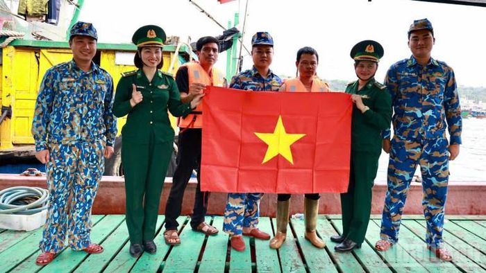 Cán bộ, chiến sĩ Bộ đội Biên phòng thành phố Hải Phòng tặng cờ Tổ quốc và áo phao cho ngư dân.