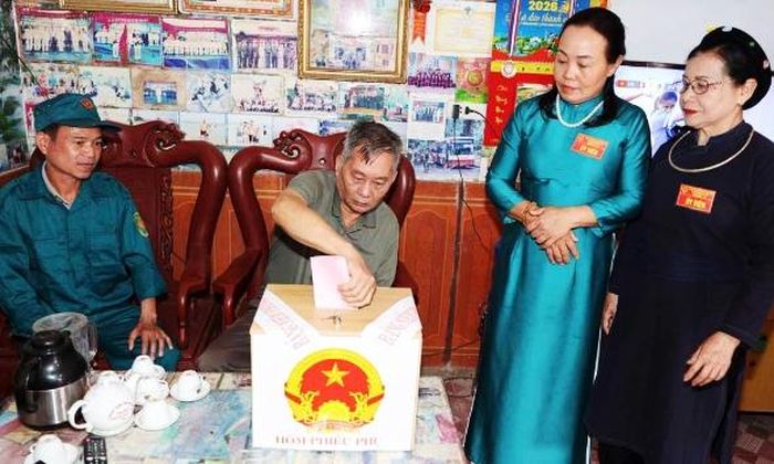 Thành viên tổ bầu cử số 3 thôn Khuân Cầu (xã Đại Sơn) đưa hòm phiếu phụ đến hộ dân.