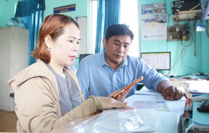 Bà Lê Thị Lan (khu phố Lâm Trúc 2, phường Hoài Nhơn) hoàn tất cài đặt tài khoản cùng ứng dụng nhật ký khai thác điện tử cho 4 tàu cá. Ảnh: Trọng Lợi