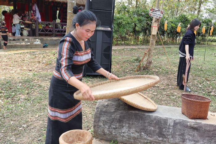 Người phụ nữ X’tiêng trình diễn công đoạn sàng gạo, tái hiện sinh hoạt lao động quen thuộc trong đời sống thường ngày của đồng bào. Ảnh: Trần Phương