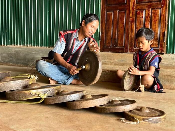  Ông Ang Lang dạy một em nhỏ trong làng chơi cồng chiêng. Ảnh: Lam Nguyên 