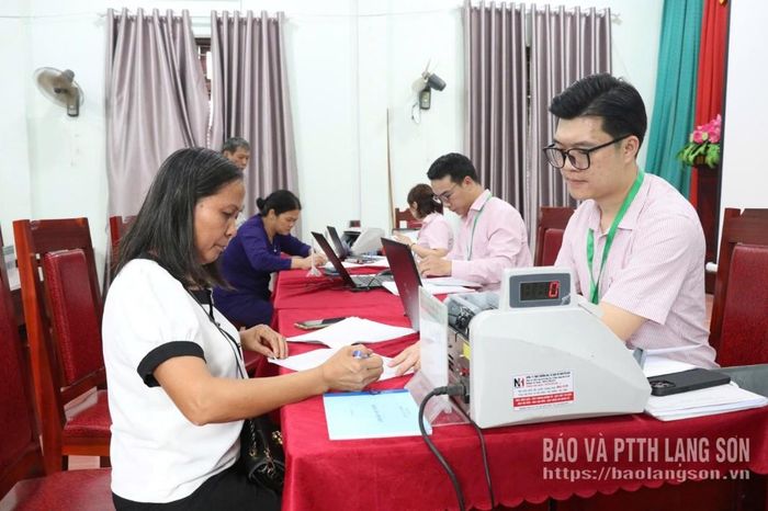 Cán bộ Phòng Giao dịch NHCSXH Đình Lập tuyên truyền, hướng dẫn khách hàng vay vốn ngân hàng