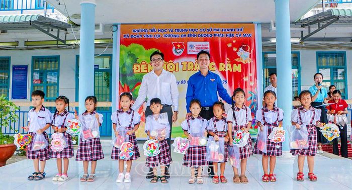 Anh Ngô Quốc Quận (bên phải) trao quà trung thu cho thiếu nhi xã Vĩnh Lợi (Ảnh nhân vật cung cấp).