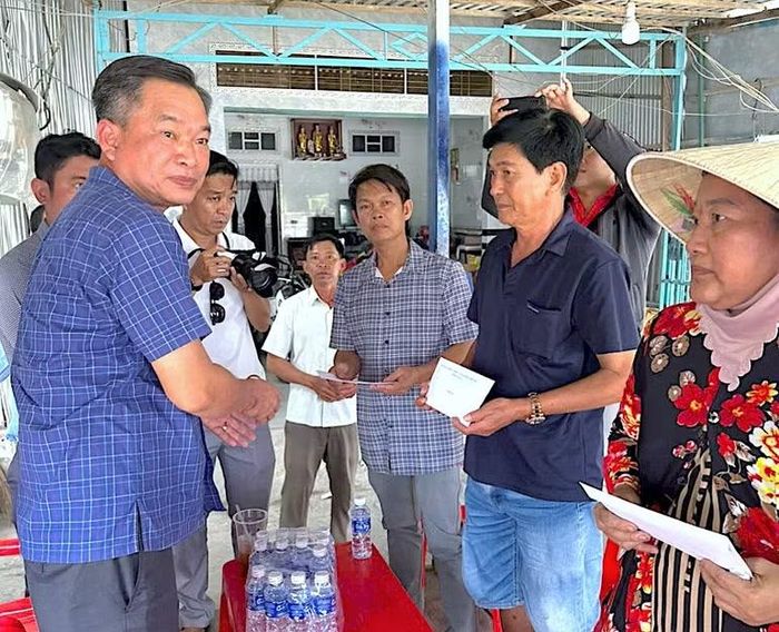 Phó Chủ tịch Ủy ban Mặt trận Tổ quốc Việt Nam tỉnh Cà Mau Nguyễn Văn Khởi (bìa trái) trao hỗ trợ bước đầu của tỉnh cho các hộ dân có nhà bị cháy ở xã Tân Tiến.