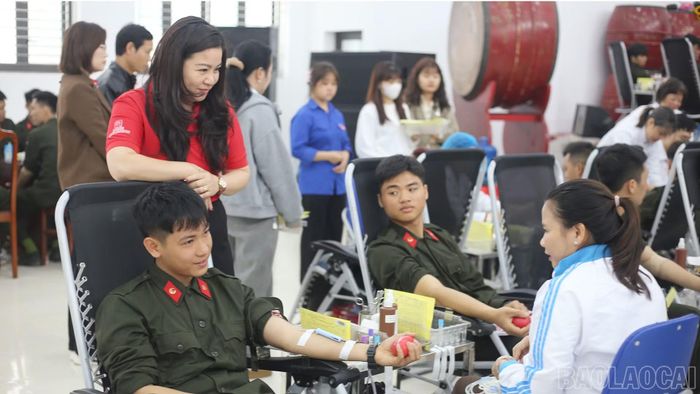 Bà Hà Thị Ngoan – Chủ tịch Hội Chữ thập đỏ tỉnh (áo đỏ) thăm hỏi, động viên người tham gia hiến máu tình nguyện.