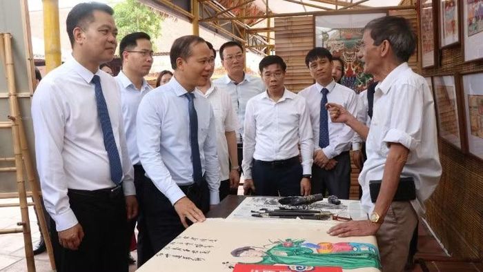 Các đại biểu động viên, trao đổi với nghệ nhân tranh dân gian truyền thống.