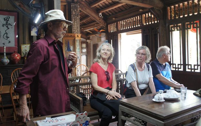 Ông Hà Nguyên Huyến giới thiệu về ngôi nhà cổ của gia đình với đoàn du khách đến từ Đức.
