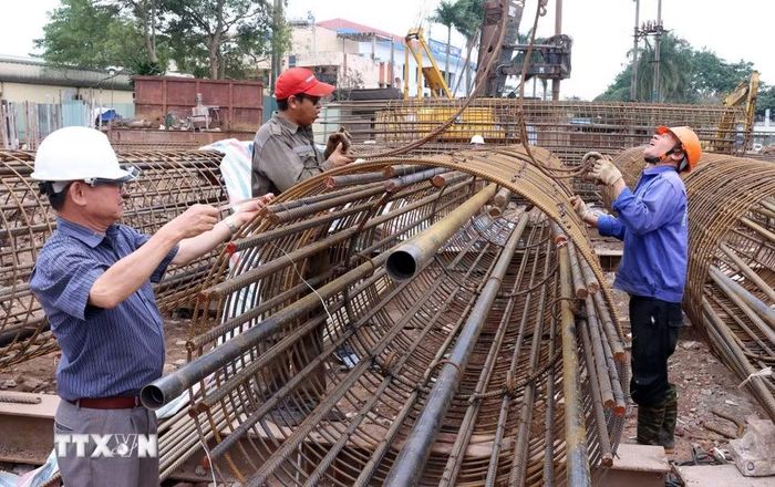 Công nhân thi công trụ sắt cọc khoan nhồi trên cạn phía đường Ngô Gia Tự. Ảnh: Quốc Khánh/TTXVN)