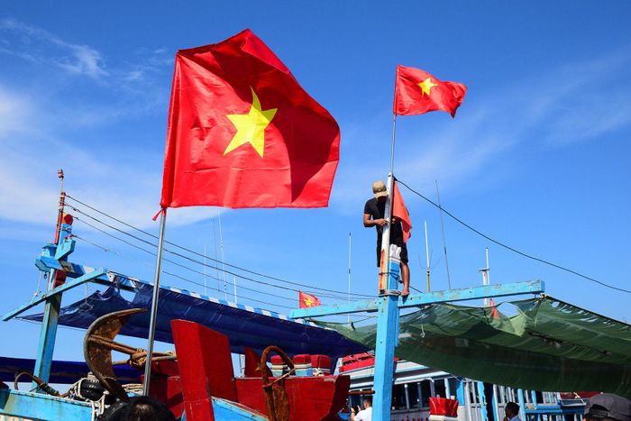 Ngư dân thay cờ Tổ quốc mới trên tàu cá