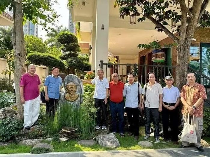 Các nhà văn quân đội và con trai nhà văn Xuân Thiều - Nguyễn Thiều Quang (áo đỏ) bên phù điêu nhà văn Xuân Thiều trong vườn Bảo tàng nghệ thuật Quang San.