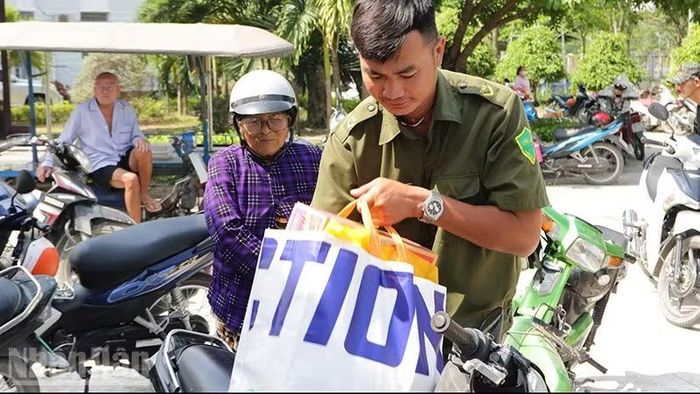 Lực lượng an ninh, trật tự cơ sở xã giúp bà con nhân dân mang quà ra xe.