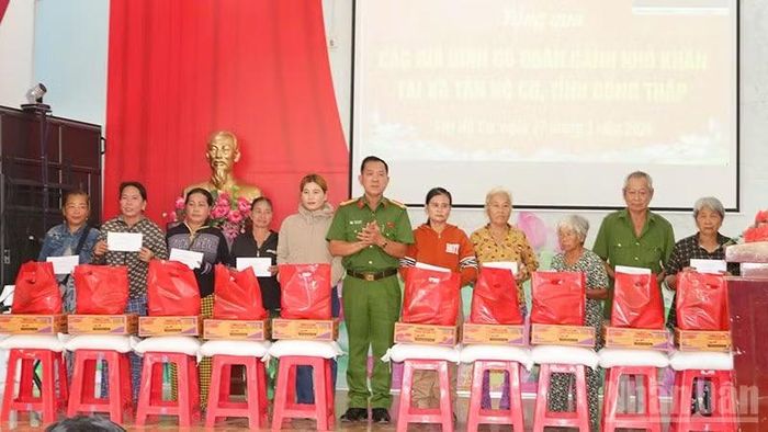 Đại tá Trần Văn Tròn, Phó Giám đốc Công an tỉnh Đồng Tháp trao các phần quà tặng người dân có hoàn cảnh khó khăn của xã Tân Hộ Cơ.
