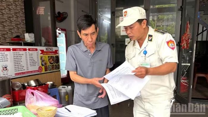 Lực lượng chức năng phường Hải Châu đã tuyên truyền, cấp phát hàng trăm tờ rơi, bản cam kết cho các hộ kinh doanh trên các tuyến đường trọng điểm của phường. Ảnh chụp sáng ngày 28/3.