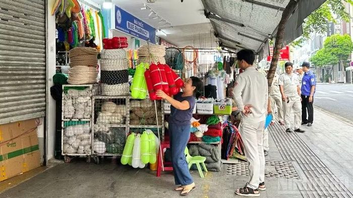 Lực lượng chức năng phường Hải Châu tuyên truyền, nhắc nhở các hộ kinh doanh khu vực chợ Hàn thu gọn hàng hóa, bảo đảm mỹ quan đô thị, sáng ngày 28/3.