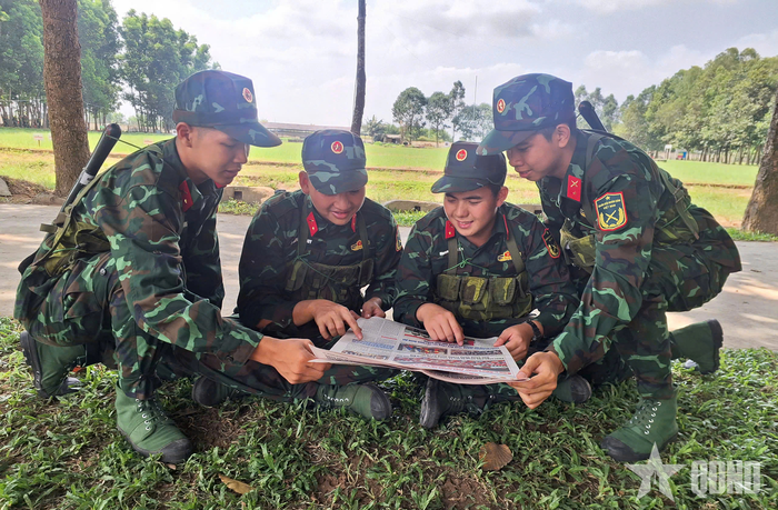 Binh nhì Nguyễn Hồ Nhất Hào (thứ 2 từ phải qua) cùng đồng đội đọc báo trong giờ nghỉ giải lao. 