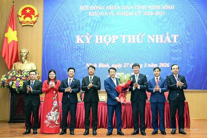 Bí thư Tỉnh ủy Trần Huy Tuấn tặng hoa chúc mừng các đồng chí được bầu giữ chức danh lãnh đạo UBND tỉnh khóa XVI, nhiệm kỳ 2026-2031. Ảnh: Trường Giang.