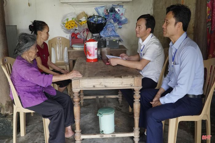 Hình ảnh cán bộ tận tình hướng dẫn cụ Võ Thị Liên (thôn Trung Long, xã Đồng Lộc) hoàn thiện thủ tục, thể hiện sự chu đáo, gần gũi và trách nhiệm trong phục vụ Nhân dân.