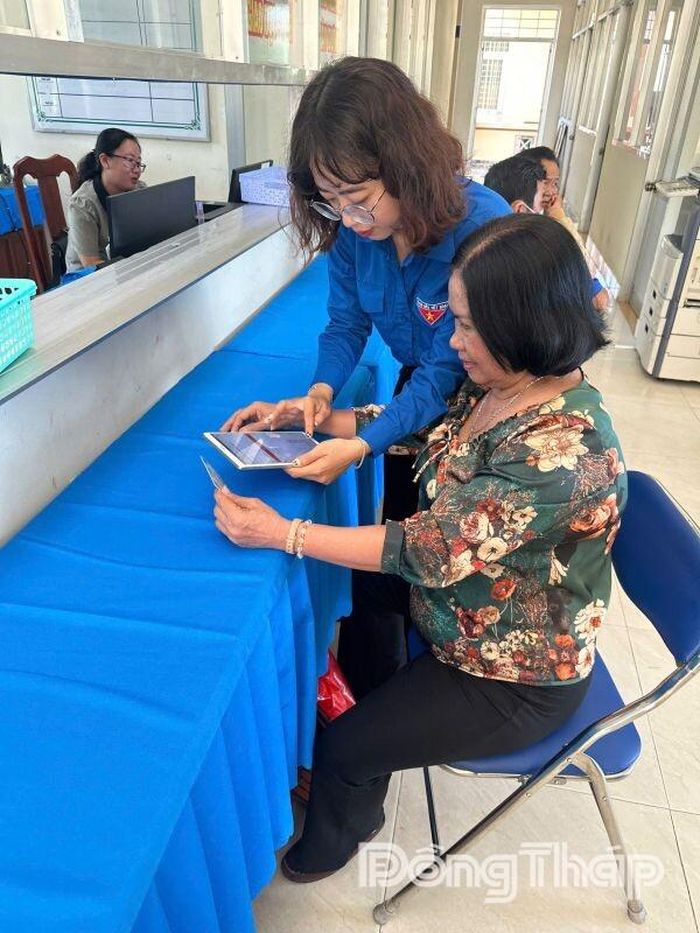 Đoàn viên hỗ trợ người dân thực hiện thủ tục hành chính và cài đặt ứng dụng số tại bộ phận “Một cửa”.