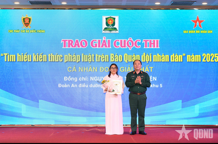 Thiếu tướng Đoàn Xuân Bộ, Tổng biên tập Báo Quân đội nhân dân, đồng Trưởng ban chỉ đạo Cuộc thi trao giải Nhất tặng đồng chí Nguyễn Thị Thanh Tiện. Ảnh: TUẤN HUY