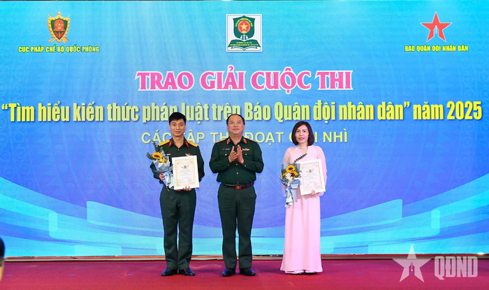 Thiếu tướng Đoàn Xuân Bộ, Tổng biên tập Báo QĐND, đồng Trưởng ban chỉ đạo Cuộc thi trao giải Nhì tặng đại diện các tập thể đoạt giải. Ảnh: HÁN TRANG