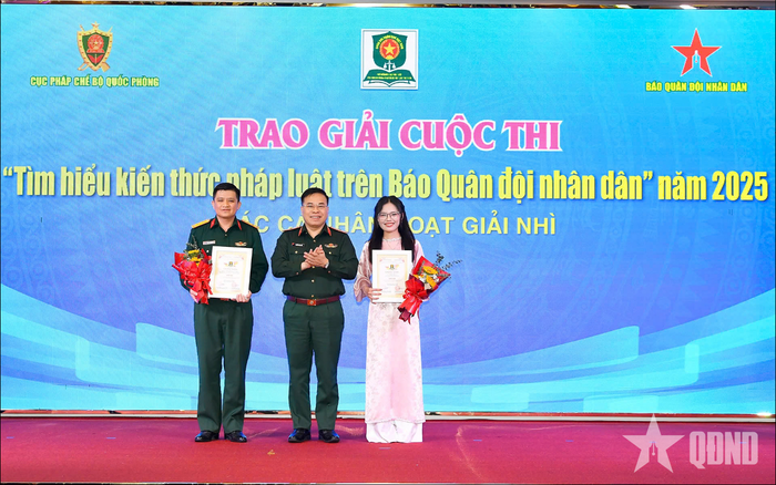 Thiếu tướng Nguyễn Việt Dũng, Cục trưởng Cục Pháp chế (Bộ Quốc phòng), đồng Trưởng ban chỉ đạo Cuộc thi trao giải Nhì tặng các cá nhân đoạt giải. Ảnh: HÁN TRANG