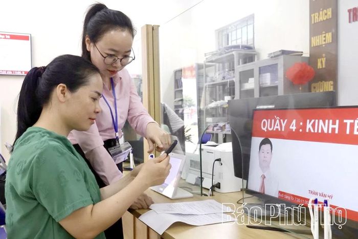 Cán bộ Trung tâm Phục vụ hành chính công xã Đạo Trù hướng dẫn người dân làm các thủ tục hành chính trực tuyến.