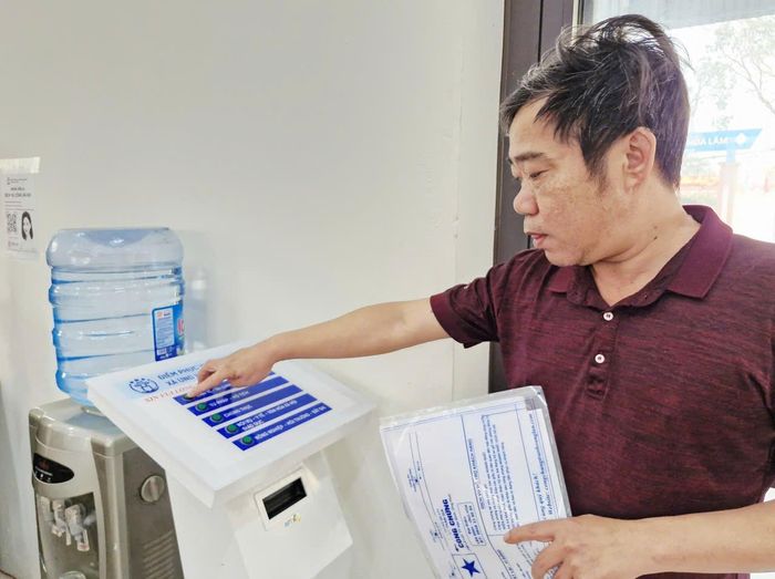 Người dân lấy số tự động tại Điểm phục vụ hành chính công xã Ứng Hòa. Ảnh: Hoàng Sơn