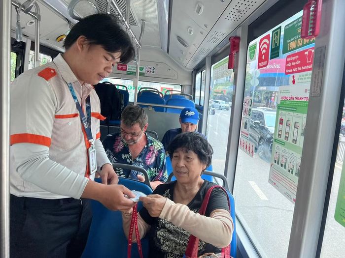 Bà Nguyễn Thị Phương Anh (75 tuổi) đưa thẻ đi xe buýt miễn phí cho nhân viên. Ảnh: Hữu Huy