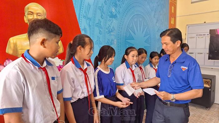  Ông Hồ Văn Khánh, Phó Hiệu trưởng Trường THCS Nguyễn Huệ, trao 20 suất học bổng cho học sinh dân tộc Khmer có hoàn cảnh khó khăn.
