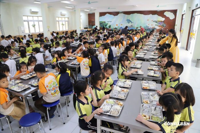 Giáo viên hoặc nhân viên hỗ trợ phát khay ăn cho học sinh. Toàn bộ quá trình được thực hiện nhanh gọn, đúng giờ để học sinh dùng bữa khi thức ăn còn nóng, giữ được chất lượng tốt nhất.
