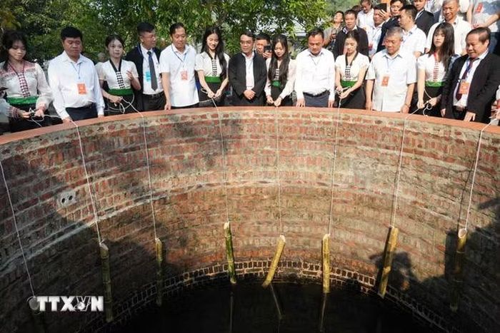 Các cô gái Thái múc nước tại nơi Nàng Han tắm gội sau khi đánh thắng giặc trước khi bay về trời. (Ảnh: Nguyễn Oanh/TTXVN)