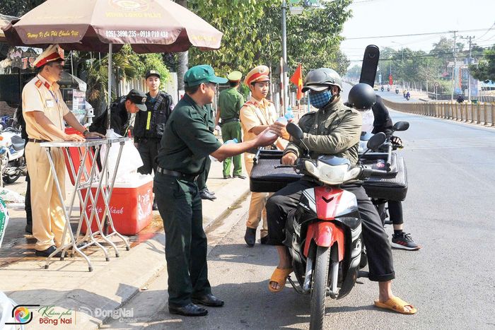 Cán bộ, chiến sĩ Công an tỉnh Đồng Nai tặng nước suối miễn phí, tiếp sức cho người đi đường ở phường Long Khánh. Ảnh: Nguyễn Thị Tỉnh