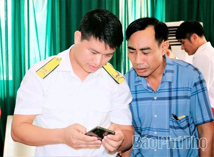 Cán bộ ngành Thuế hướng dẫn người dân tiếp cận chuyển đổi số trong lĩnh vực thương mại điện tử, quản lý hóa đơn.