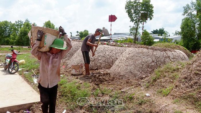 Những người thợ vận chuyển đất để bồi đắp mộ.