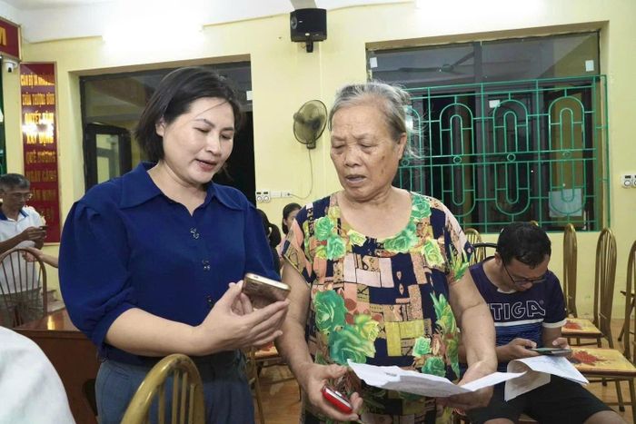 Lãnh đạo xã Thường Tín hướng dẫn người dân trong việc ứng dụng công nghệ thông tin. Ảnh: PV