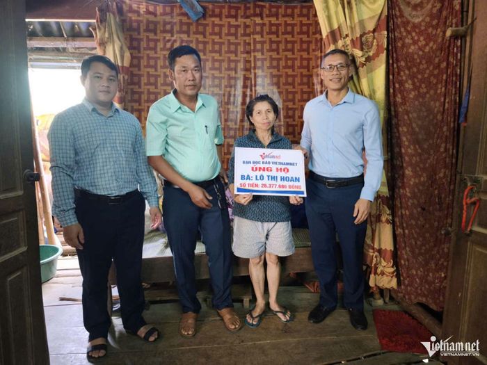 Đại diện Báo VietNamNet phối hợp chính quyền xã Mường Xén trao số tiền 26.337.686 đồng của bạn đọc giúp đỡ gia đình bà Lô Thị Hoan. Ảnh: Thanh Hải