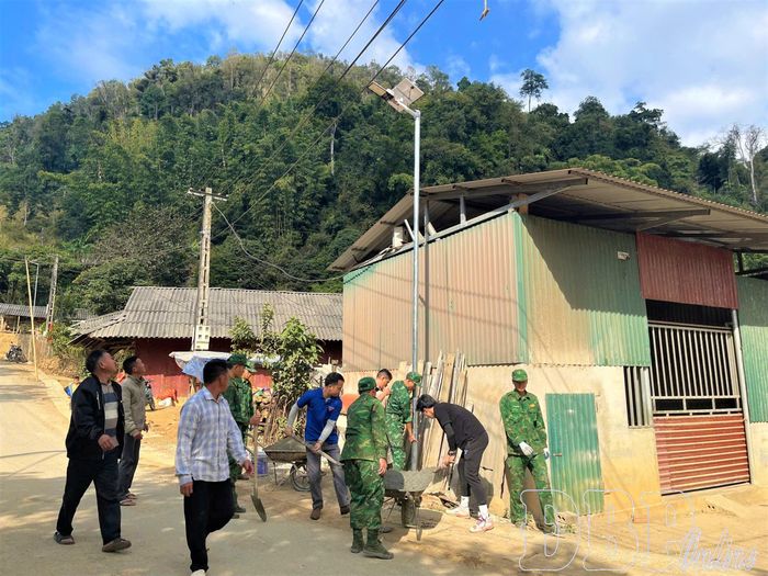 Các lực lượng tham gia lắp đặt bóng đèn năng lượng mặt trời “Thắp sáng vùng biên” tại khu vực bản Na Ư, xã Sam Mứn.