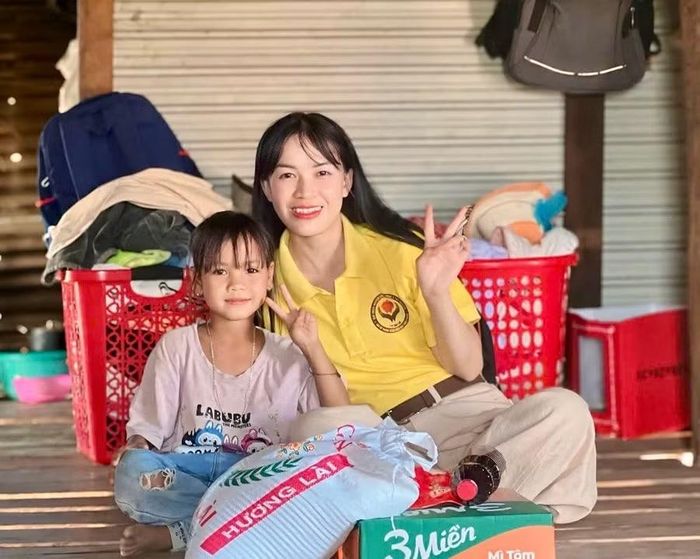Chị Lê Thị Sửu - Chủ nhiệm CLB Thiện nguyện Lửa hồng Tây Nguyên, tặng quà cho em Đinh Thị Khanh (lớp 2.2, Trường Tiểu học Lý Thường Kiệt, xã Pờ Tó). Ảnh: P.L