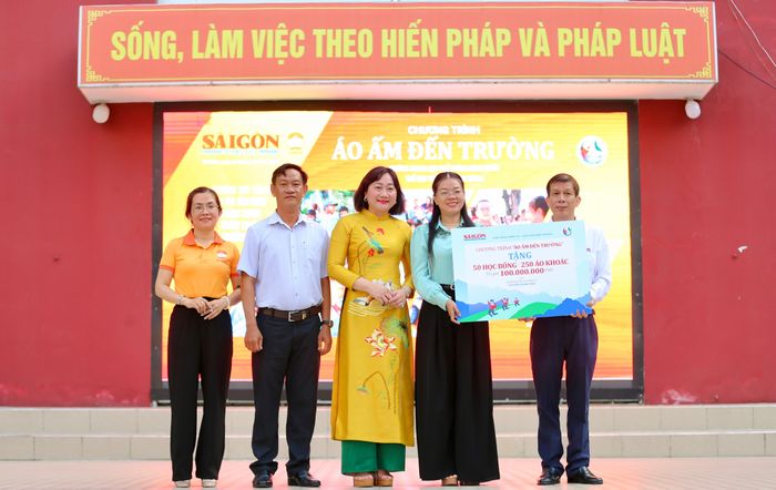  Quyền Tổng biên tập báo Sài Gòn Giải Phóng trao bảng cho đại diện Ủy ban Mặt trận Tổ quốc Việt Nam xã Bình Lợi. Ảnh: DŨNG PHƯƠNG 