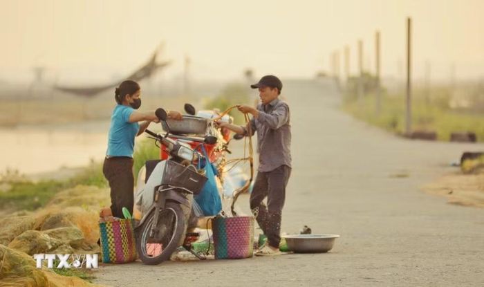 Người dân bắt đầu bán cá đầm phá từ sáng sớm. (Ảnh: Văn Dũng/TTXVN)